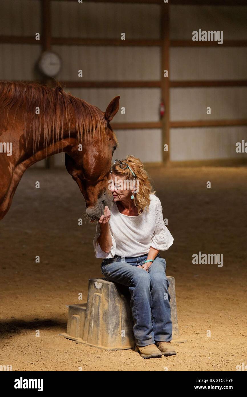 un proprietario di cavalli che tocca le teste con il suo cavallo con gli occhi chiusi Foto Stock