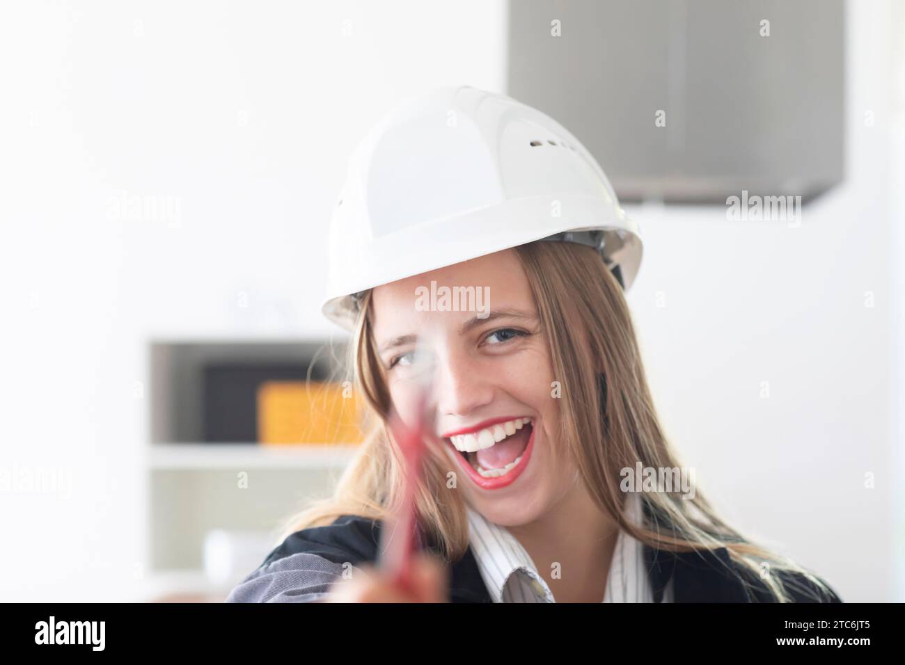 Giovane ingegnere donna con casco in un negozio di lavoro Foto Stock