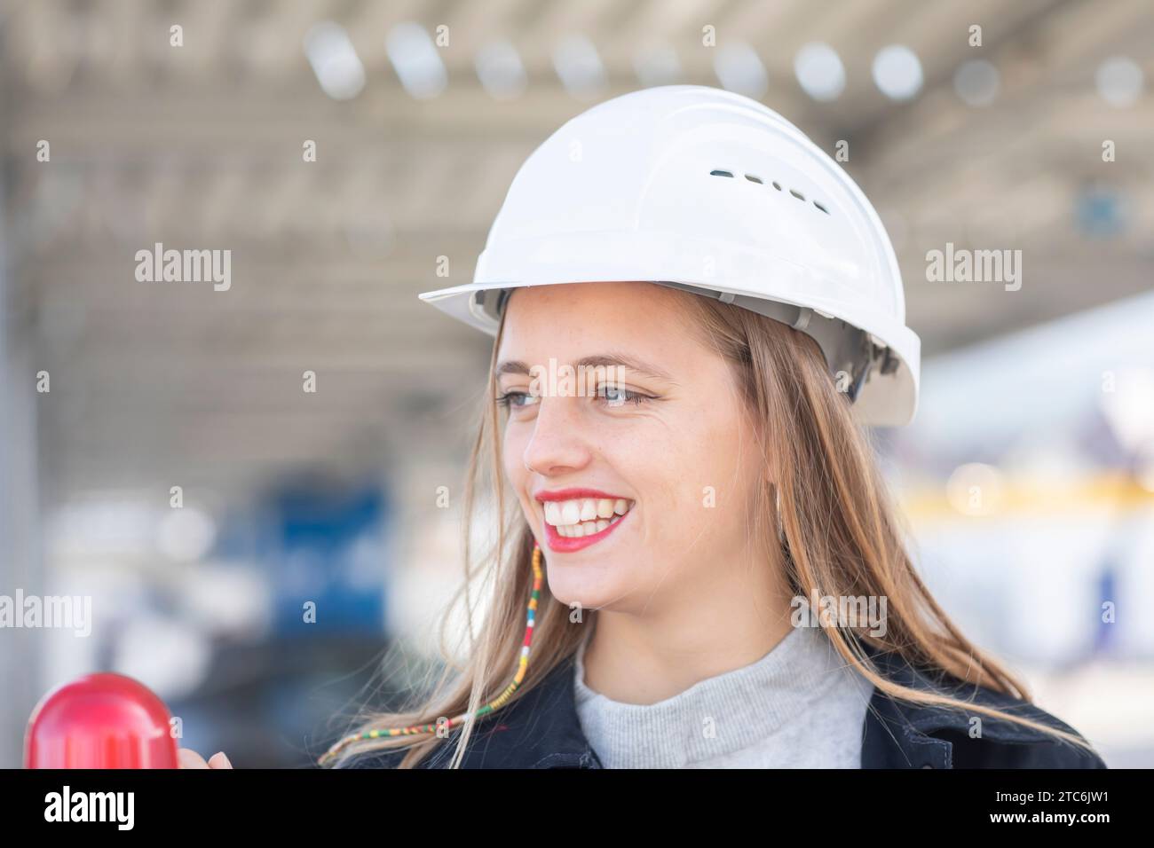 Giovane ingegnere donna con casco che guarda Foto Stock