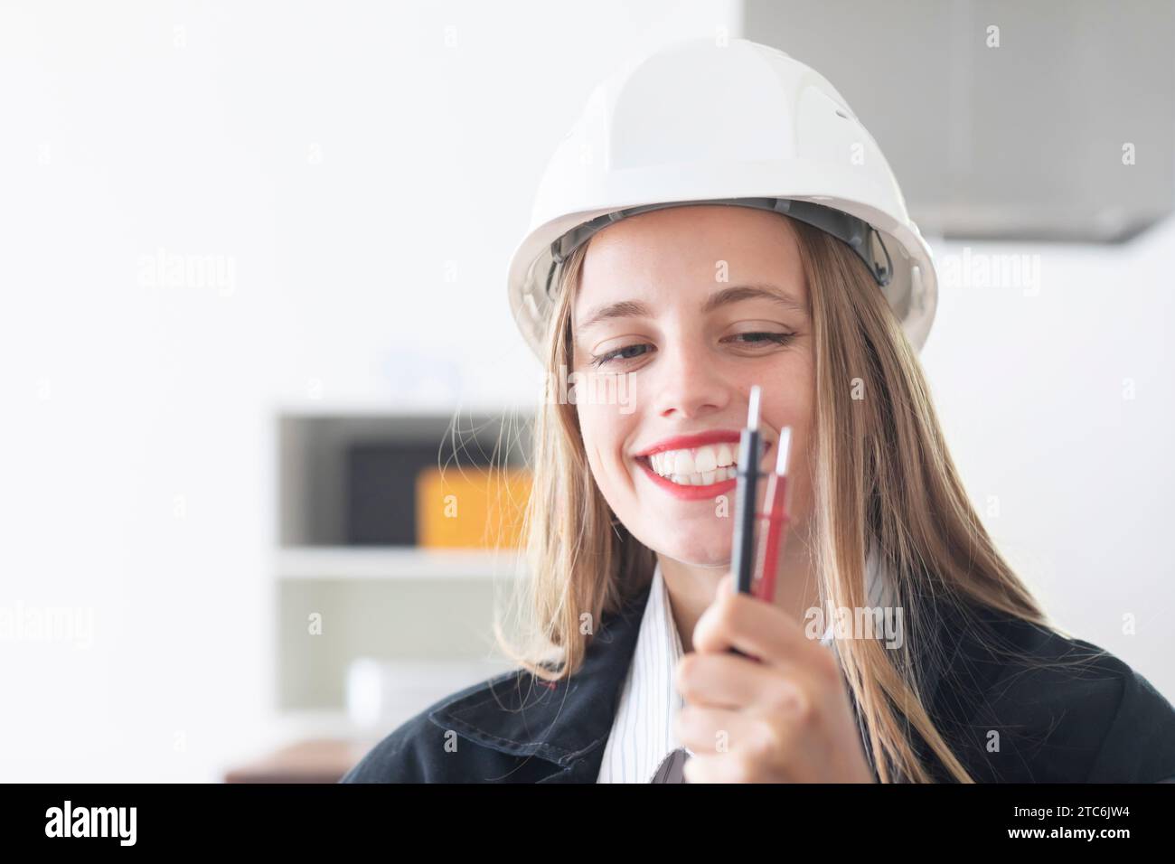 Giovane ingegnere donna con casco in un negozio di lavoro Foto Stock