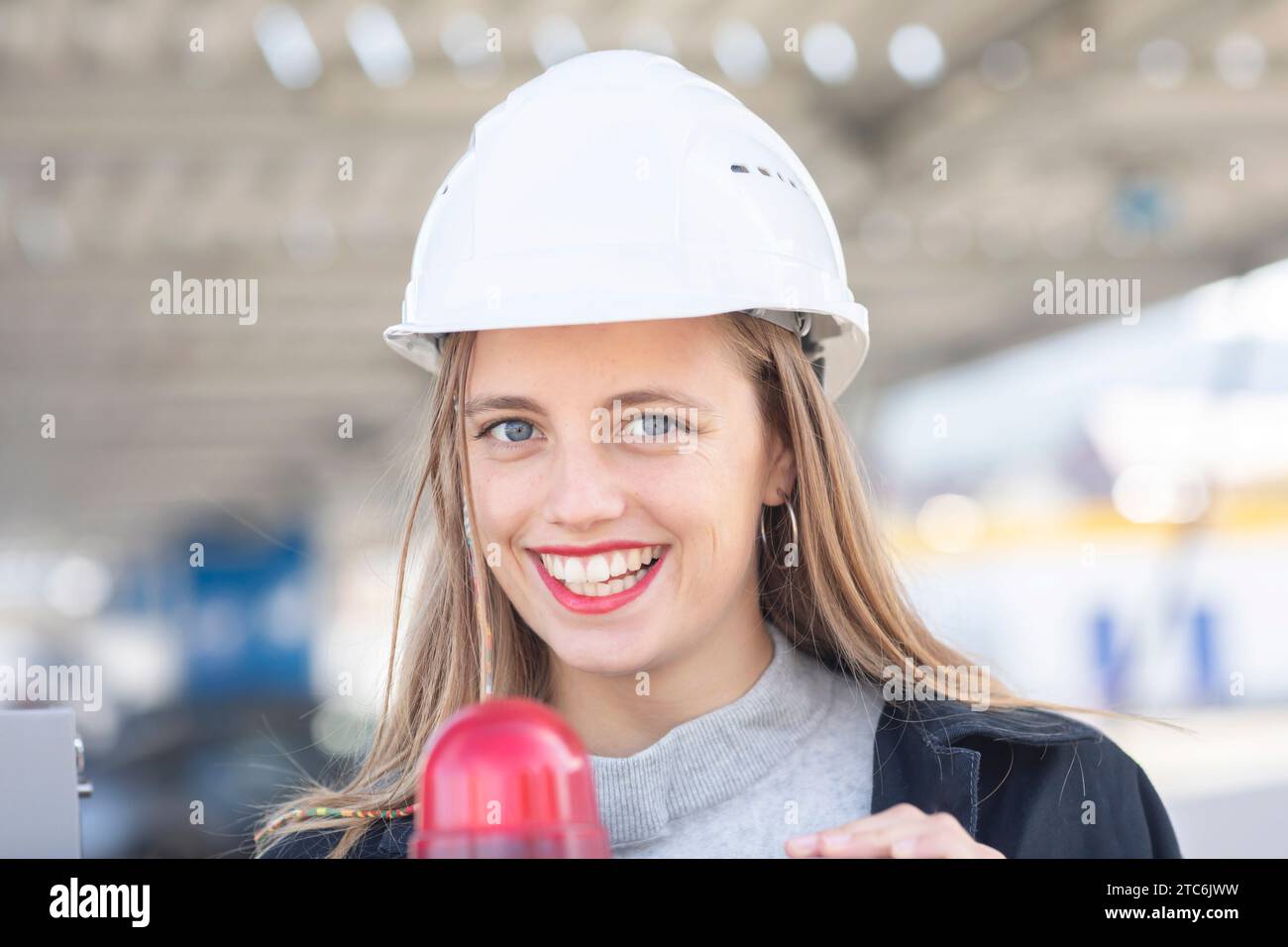 Giovane ingegnere donna con casco che guarda Foto Stock