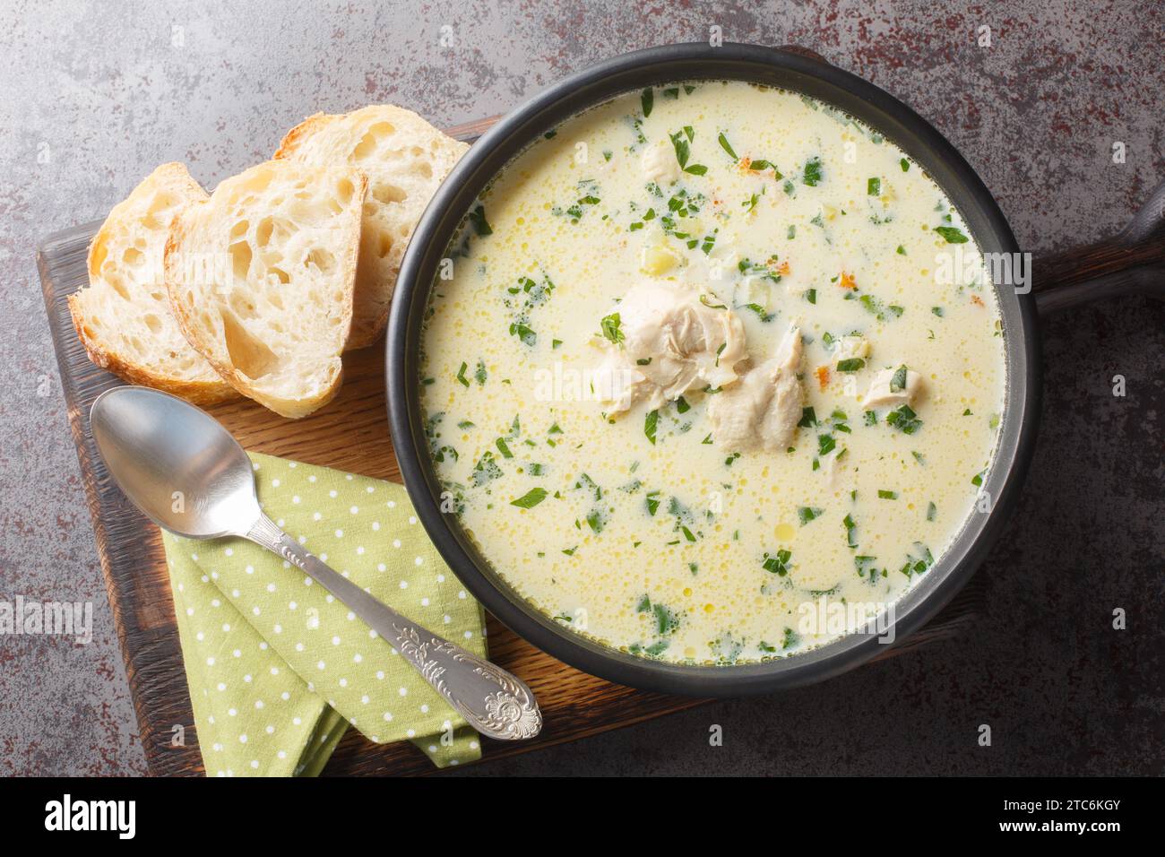 Zuppa di pollo acida fatta in casa con panna acida e verdure in un recipiente sul tavolo. Vista superiore orizzontale dall'alto Foto Stock
