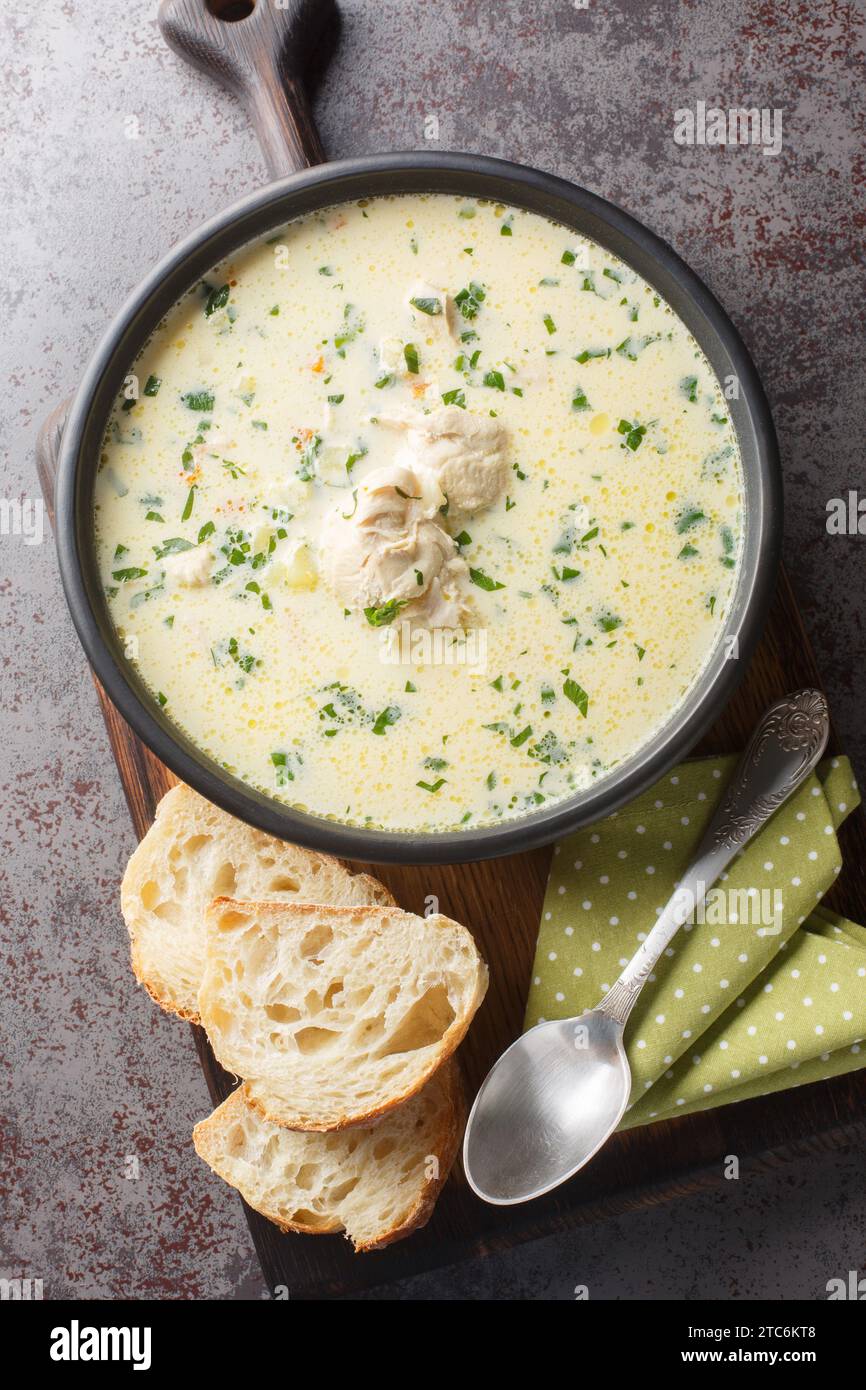 Zuppa di pollo all'aglio con panna acida rumena Radauteana primo piano sul piatto sul tavolo. Vista dall'alto verticale Foto Stock
