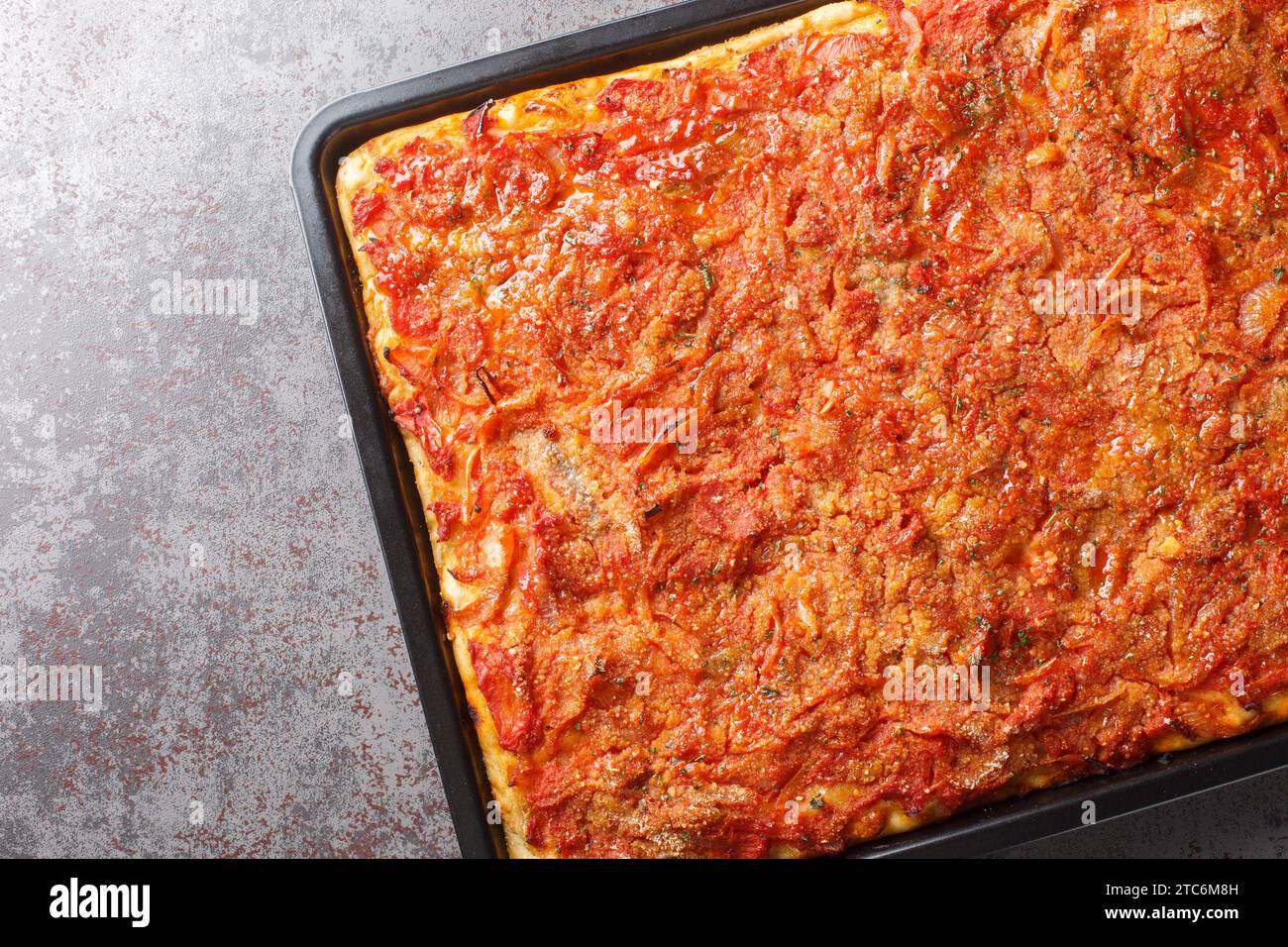 Lo Sfincione Palermitano è una pizza spessa condita con sapori forti come acciughe, caciocavallo, cipolle e salsa di pomodoro primo piano sulla cottura Foto Stock