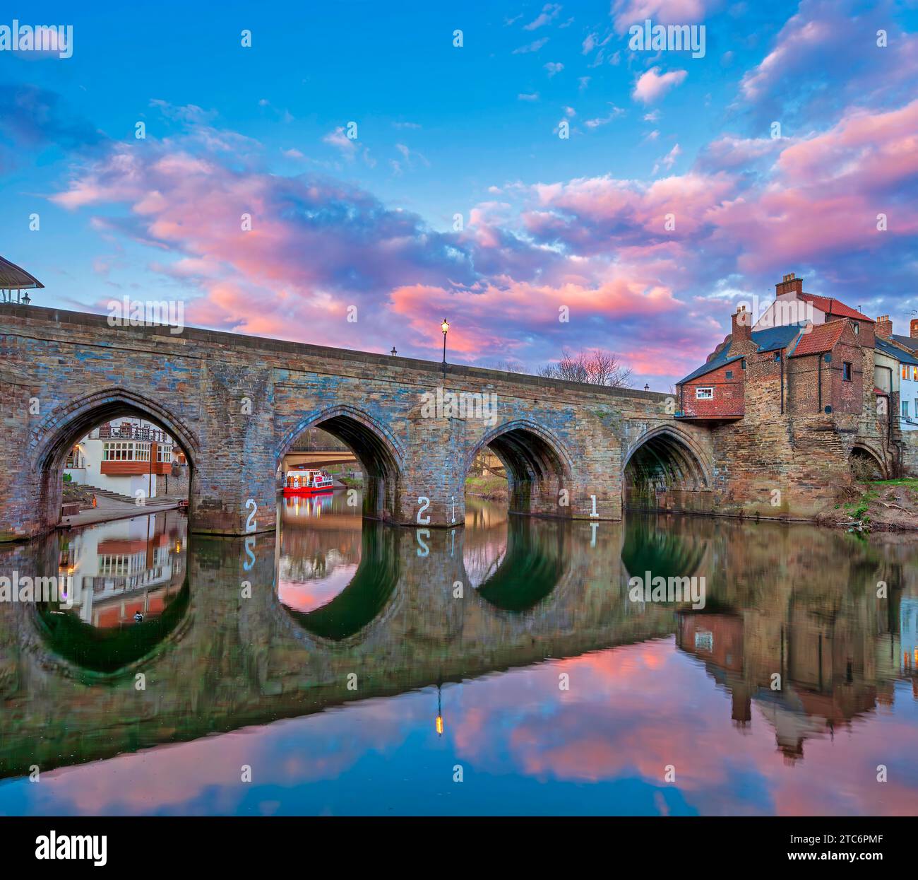 Una vista al tramonto dell'Elvet Bridge nella città di Durham riflessa nel fiume Wear che guarda verso l'alto Foto Stock