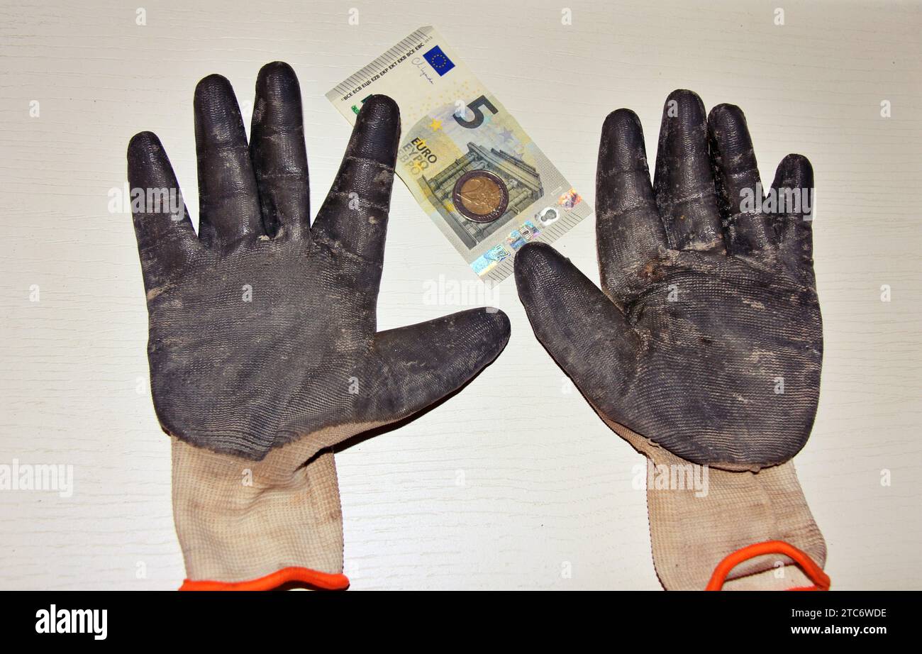 Guanti da lavoro con pochi euro, concetto di stipendio minimo. Foto Stock
