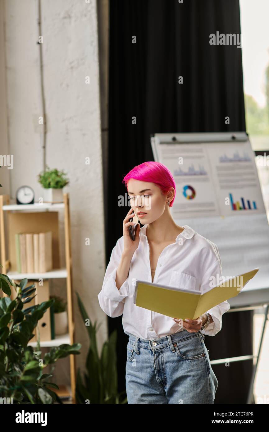 lavoratrice attraente con capelli corti rosa che tiene le sue note e parla al telefono, per lavoro Foto Stock