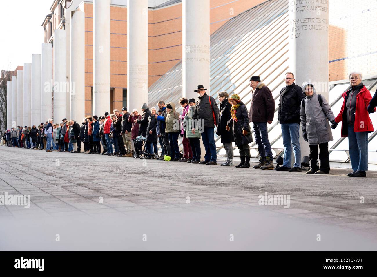 ALS Aktion zum 75. Jahrestag der Verkündung der Allgemeinen Erklärung der Menschenrechte bilden Teilnehmer eine Menschenkette in der Straße der Menschenrechte. Auf den Säulen in der Straße sind die 30 Artikel der un-Menschenrechtscharta in verschiedenen Sprachen zu lesen. Nürnberg, 10.12.2023 Bayern Deutschland *** come azione per celebrare il 75° anniversario della proclamazione della dichiarazione universale dei diritti dell'uomo, i partecipanti formano una catena umana nella strada dei diritti umani i 30 articoli della carta dei diritti umani delle Nazioni Unite possono essere letti in varie lingue sui pilastri della strada N Foto Stock