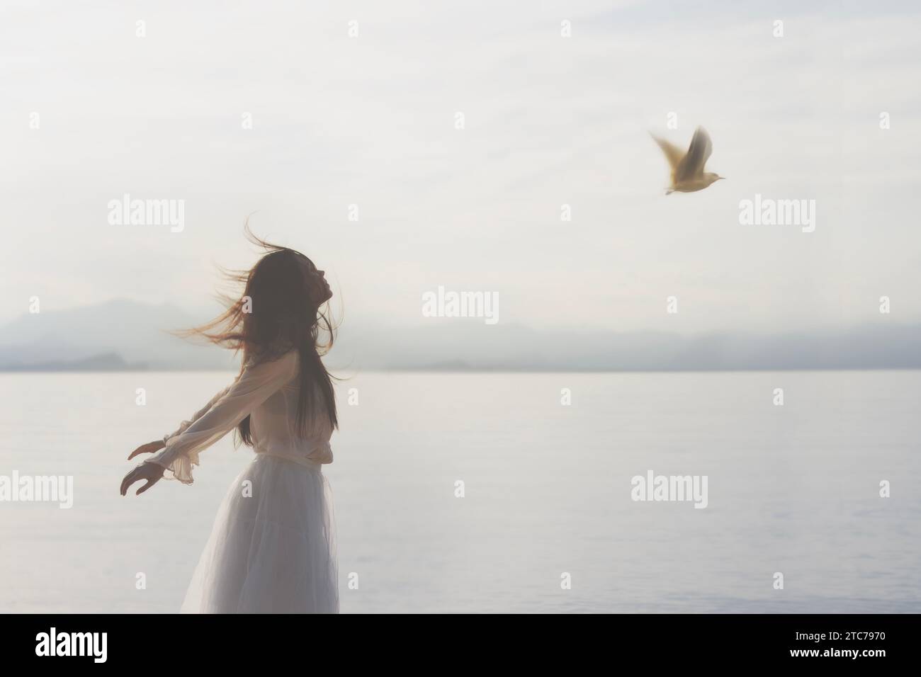 donna surreale con capelli volanti in perfetta armonia con un uccello volante, concetto astratto Foto Stock