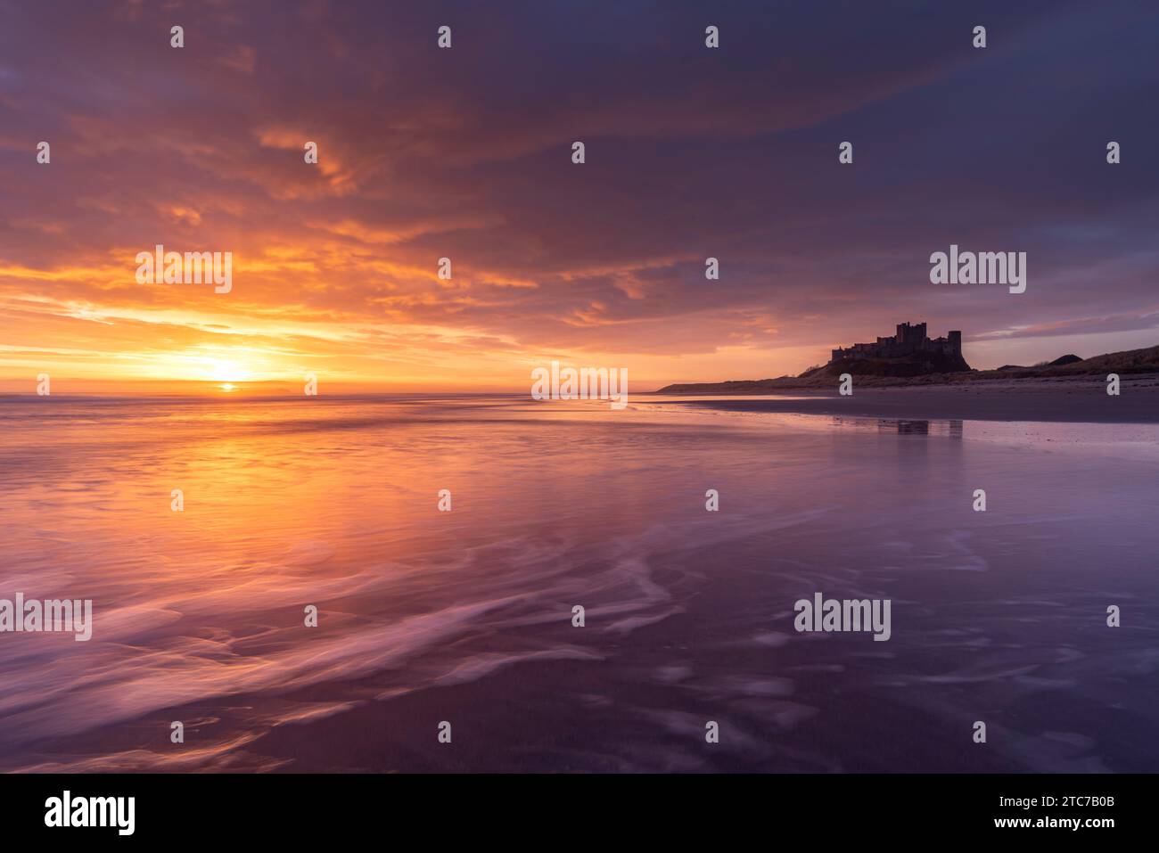 Splendida alba sopra il castello di Bamburgh sulla costa del Northumberland, Inghilterra. Primavera (marzo) 2023. Foto Stock