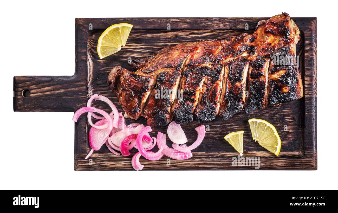 Costolette di maiale caramellate alla griglia con cipolla e limone su vassoio di legno isolato, vista dall'alto Foto Stock