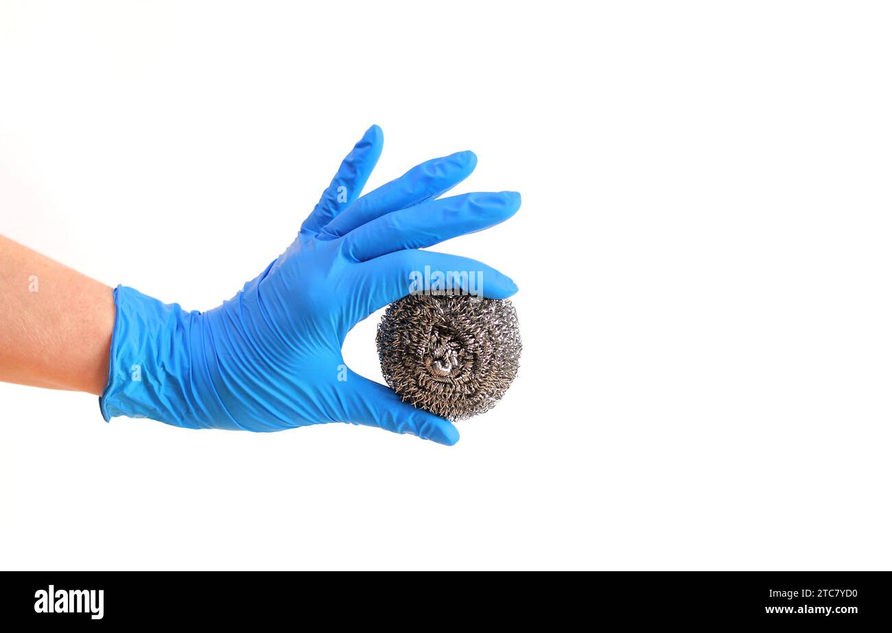 Spazzola da cucina in acciaio inox. Attrezzi per la pulizia del barbecue. Una mano in un guanto blu lattice contiene una spazzola a sfera in acciaio inox. Spazzola lavastoviglie, cucina a. Foto Stock