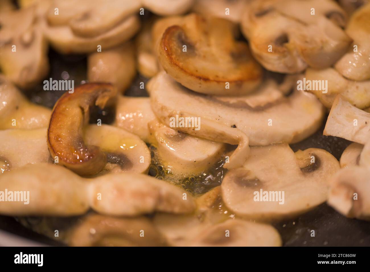 Fette di funghi frizzanti nel burro Foto Stock