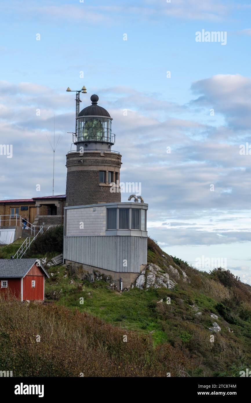 Una vista panoramica di un faro in cima a una montagna con più persone che ammirano il maestoso panorama di Varberg, Svezia Foto Stock