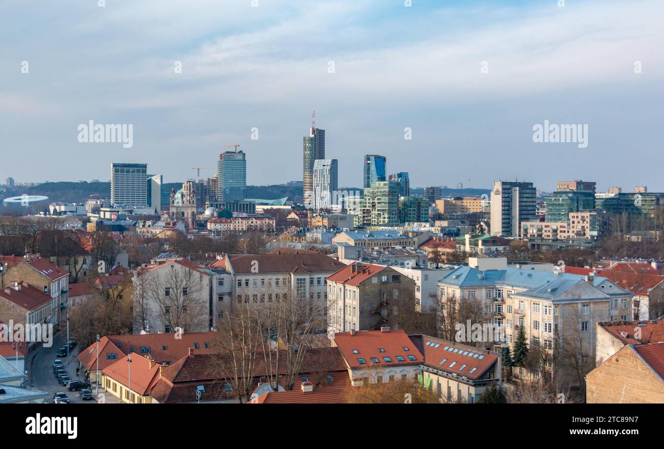 Un quadro dei contrasti architettonici di Vilnius, con appartamenti in primo piano e il moderno quartiere degli affari lontano Foto Stock