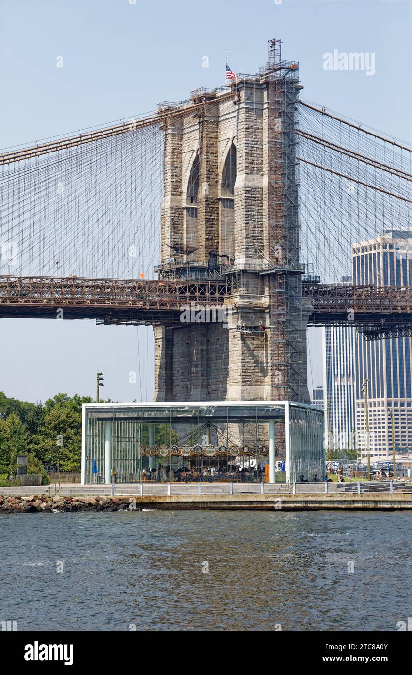 La giostra di Jane si trova all'ombra del Ponte di Brooklyn. Il divertimento per bambini, racchiuso in vetro, è stato spostato da Youngstown, Ohio. Foto Stock