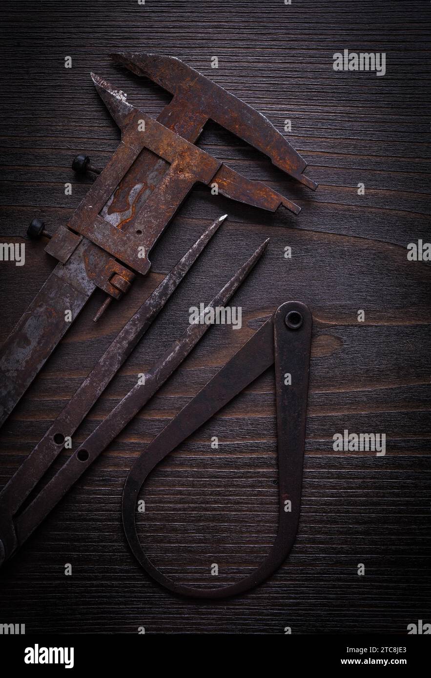Calibro a corsoio arrugginito su tavola in legno vintage Foto Stock