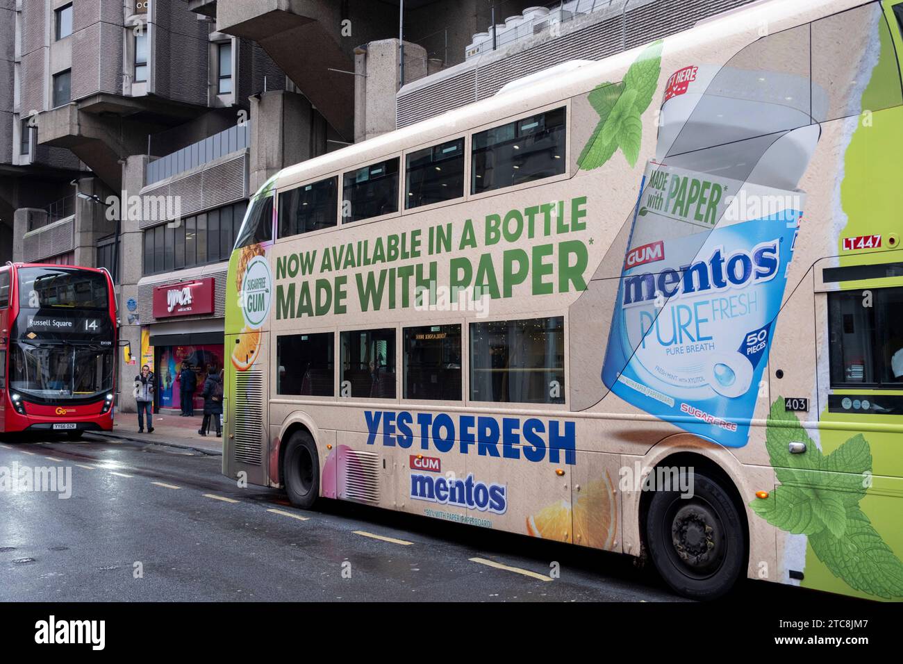 Autobus che pubblicizza imballaggi in plastica gratuiti per la gomma da masticare Mentos il 4 dicembre 2023 a Londra, Regno Unito. La bottiglia contenente la gomma viene pubblicizzata come costruita con carta e non plastica, il che la rende più sostenibile dal punto di vista ambientale. Foto Stock