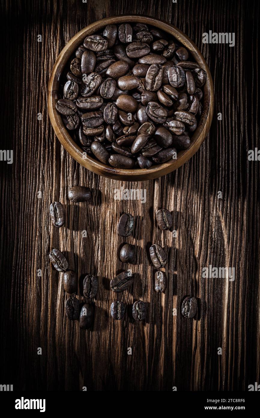 Ciotola con semi di caffè su una tavola di legno vintage Foto Stock