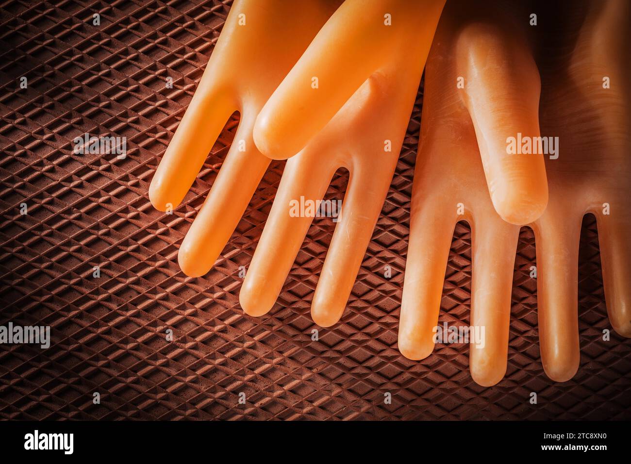 Un paio di guanti isolanti su un tappetino in gomma dielettrica Foto Stock