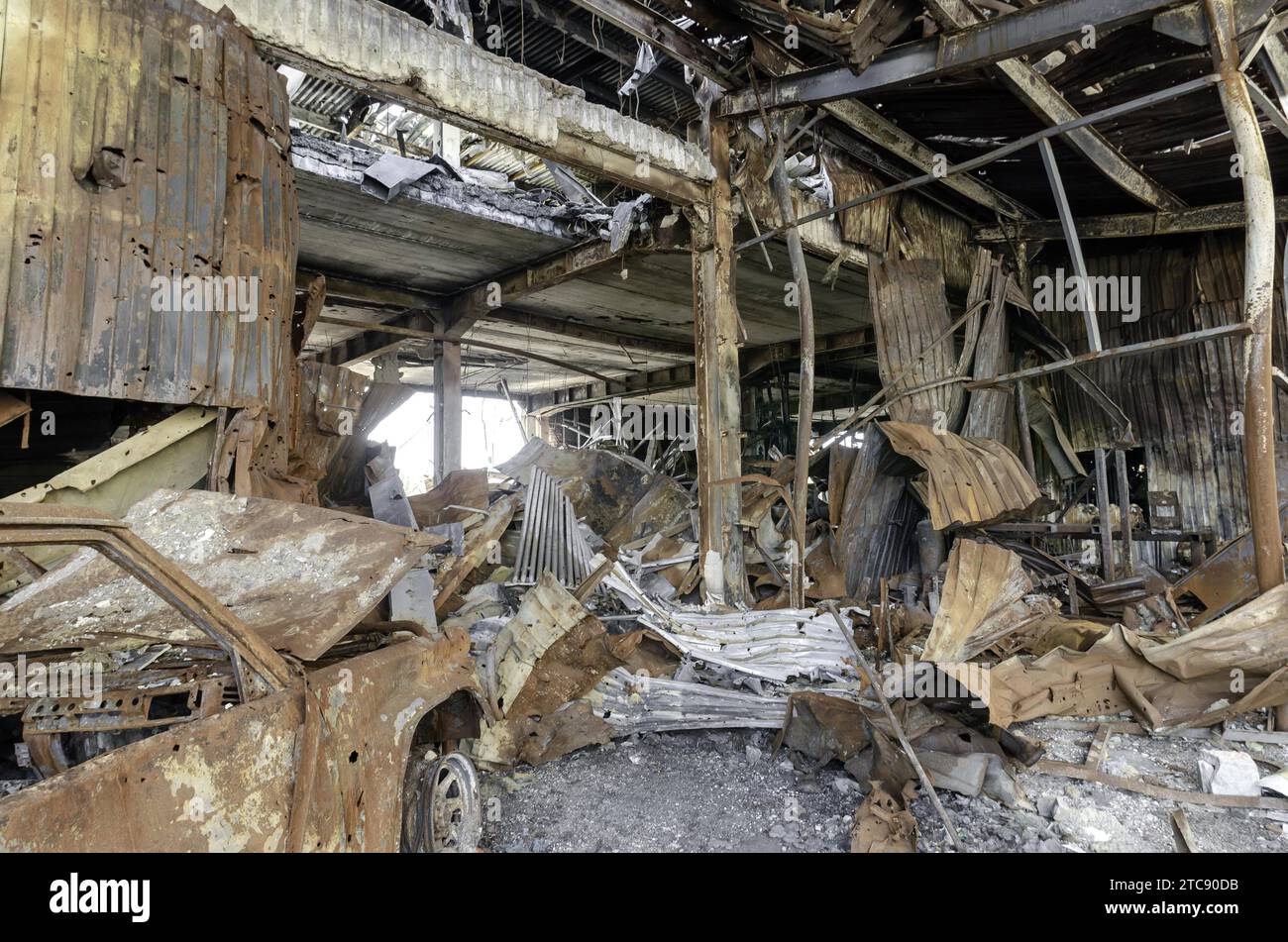 Auto corazzata militare bruciata sulla strada della guerra di città in rovina Ucraina Russia Foto Stock