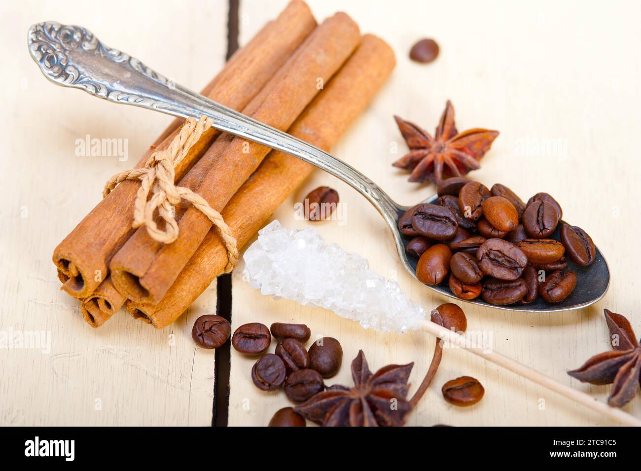 Caffè, zucchero e spezie su un cucchiaio d'argento su un tavolo rustico in legno bianco Foto Stock