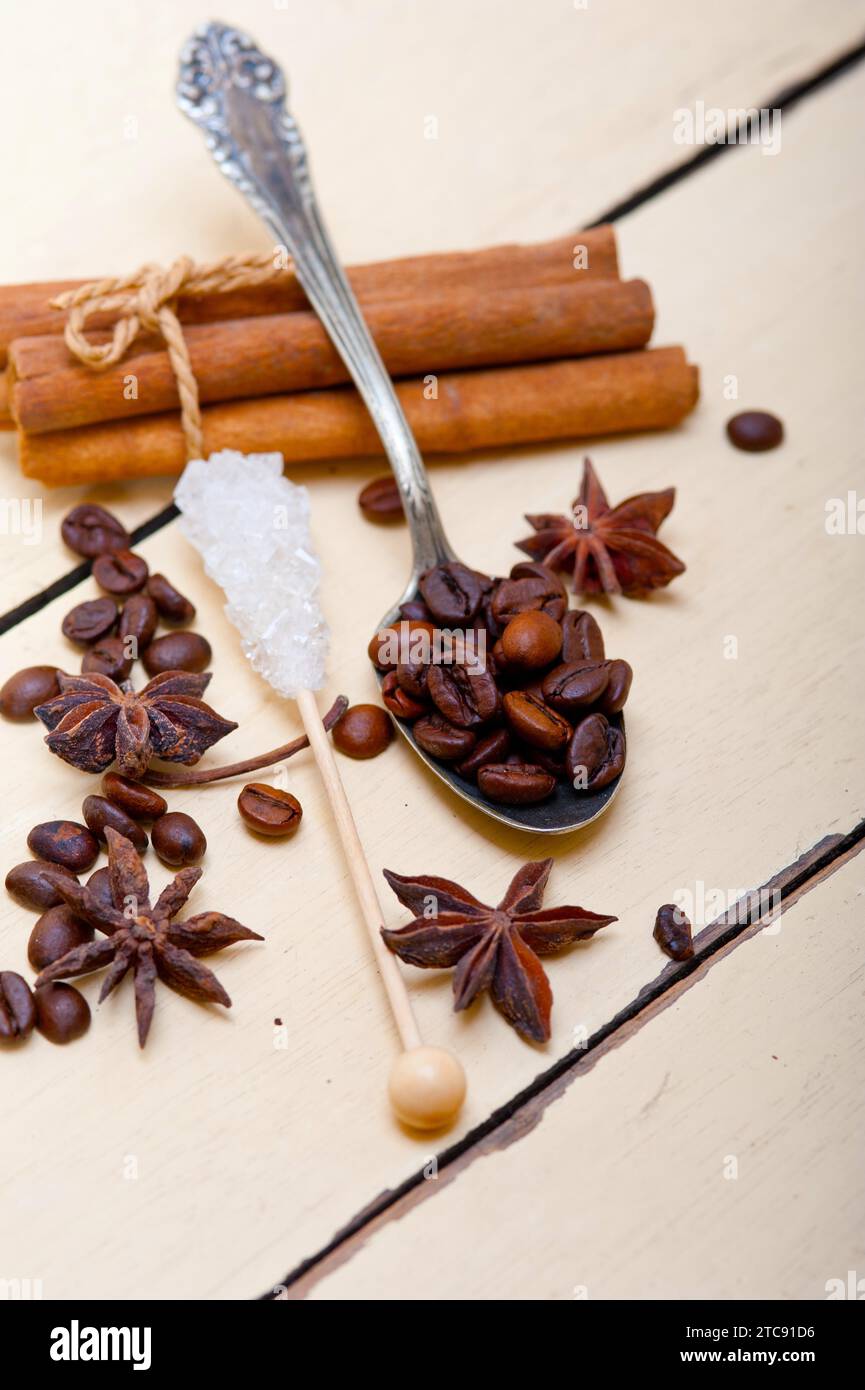 Caffè, zucchero e spezie su un cucchiaio d'argento su un tavolo rustico in legno bianco Foto Stock