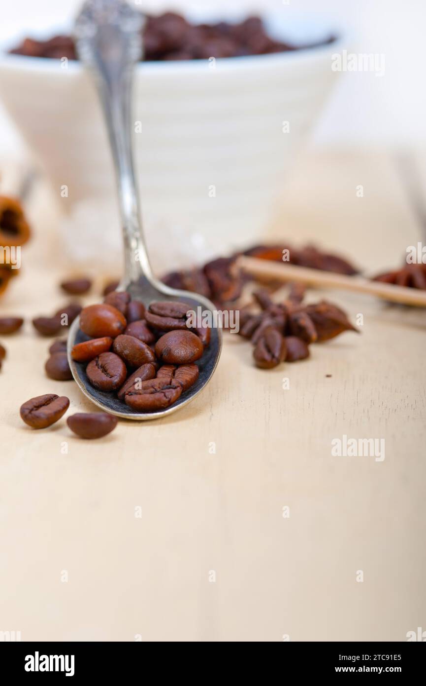 Caffè, zucchero e spezie su un cucchiaio d'argento su un tavolo rustico in legno bianco Foto Stock