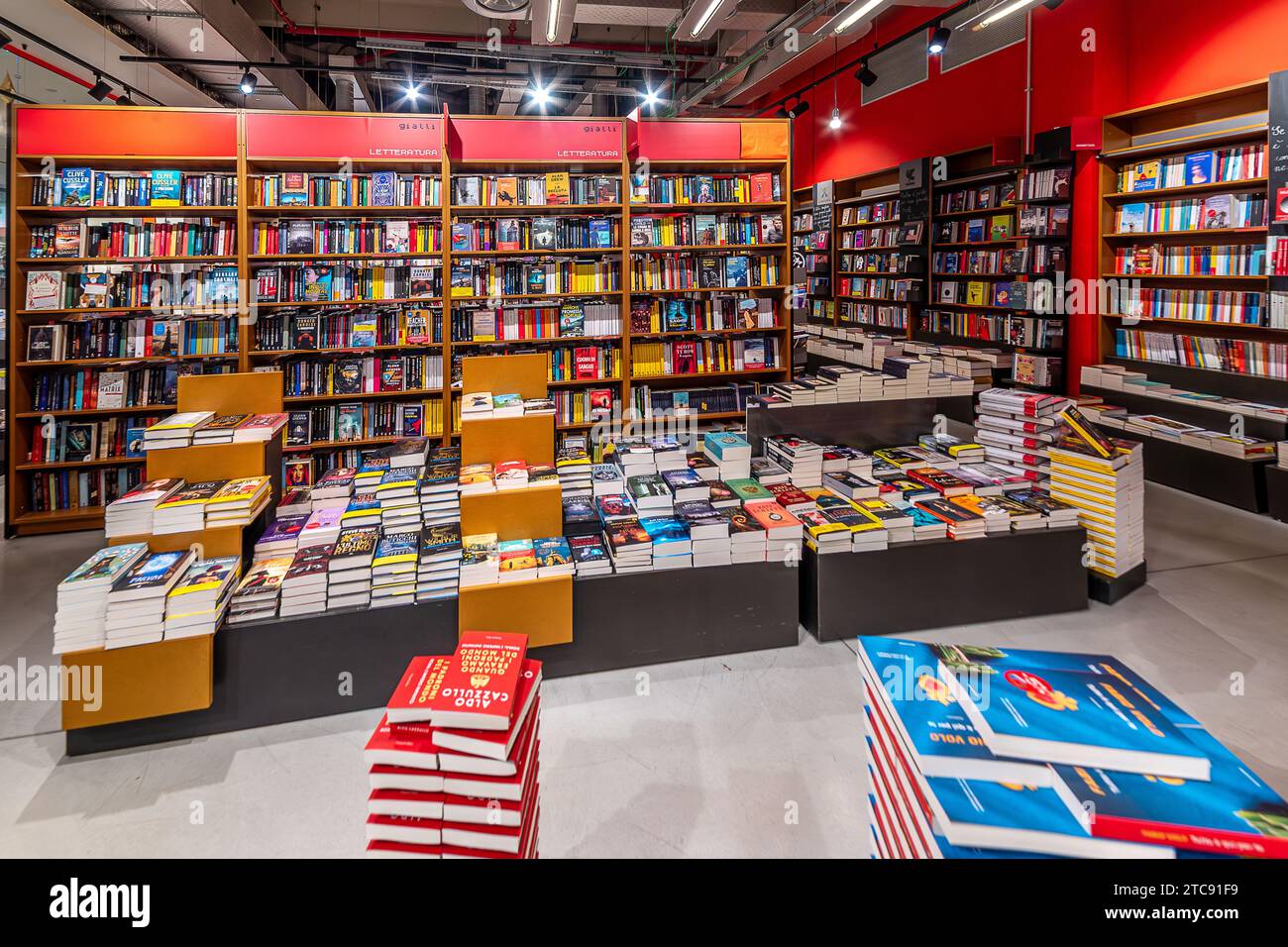 Mondovì, Piemonte, Italia - 11 dicembre 2023: Vista interna di Librerie.coop libreria con scaffali e pile di libri in vendita a Mondovicino Foto Stock