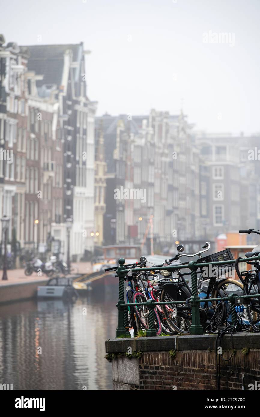 Biciclette e case vicino a un canale ad Amsterdam, Paesi Bassi Foto Stock