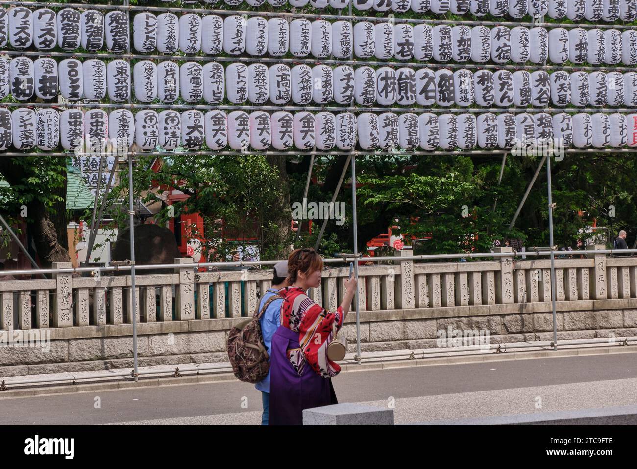 Tokyo Giappone; 13 maggio 2019: Due persone camminano lungo una strada a Tokyo accanto a una decorazione della religione buddista. Foto Stock