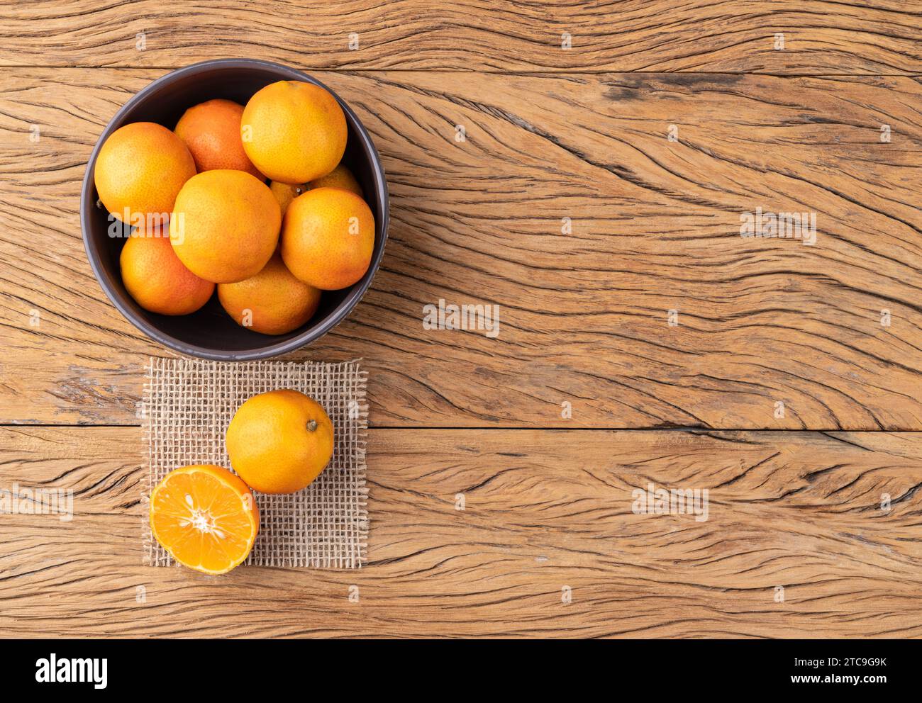 Cravo o limoni di rosa in una ciotola su un tavolo di legno con spazio per le copie. Foto Stock