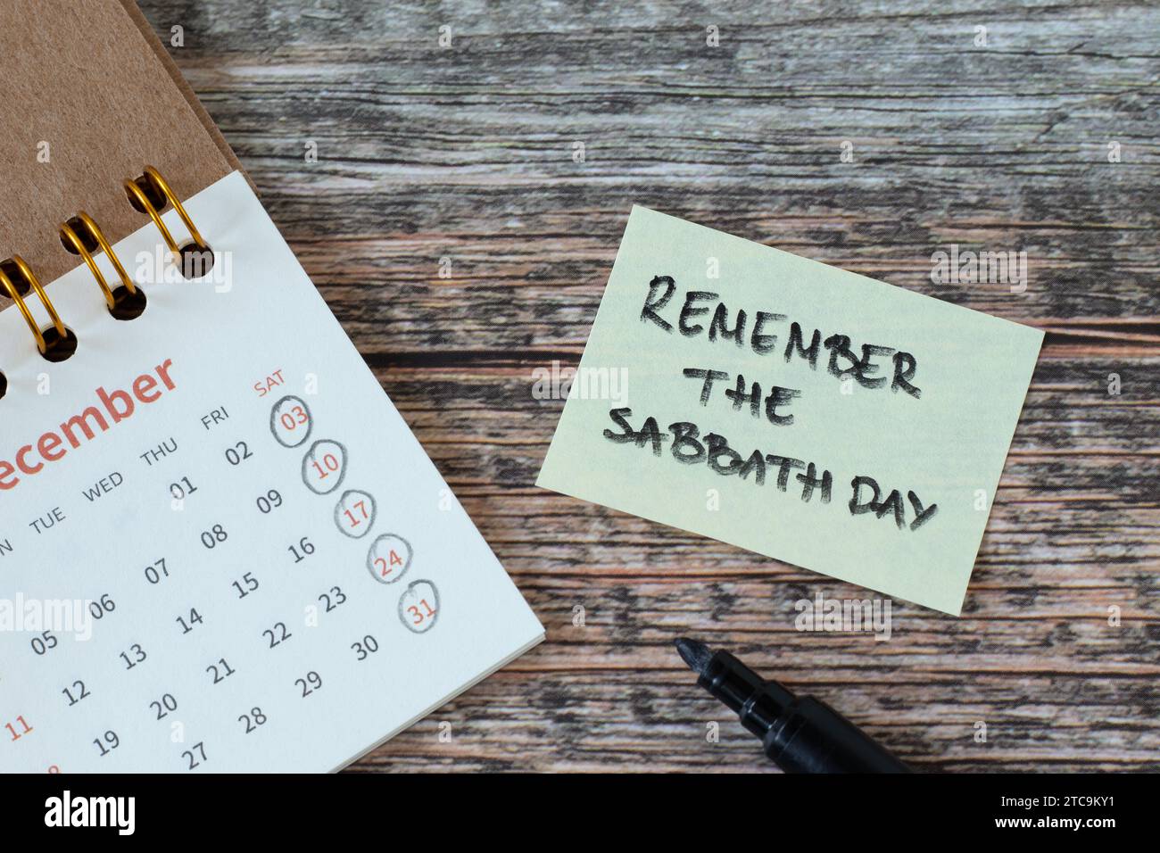 Ricordate il giorno dello Shabbat, versi scritti a mano su nota e calendario su tavolo di legno. Tempo santo cristiano, obbedienza, riposo e adorazione di Dio Gesù Cristo. Foto Stock