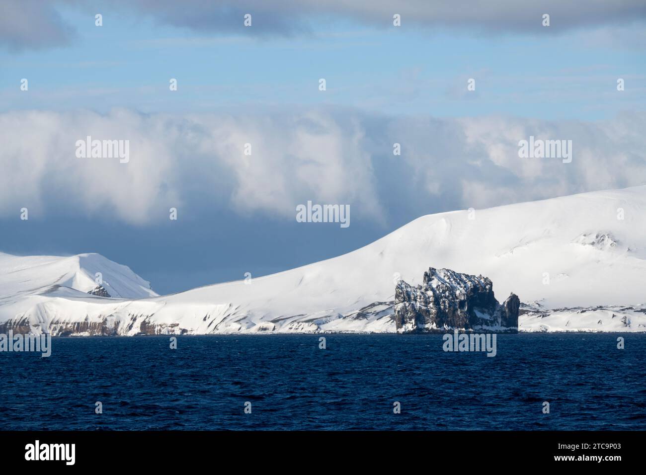 Antartide, Isole Shetland meridionali, stretto di Bransfield. New Rock con vista costiera dell'isola di Deception in lontananza Foto Stock