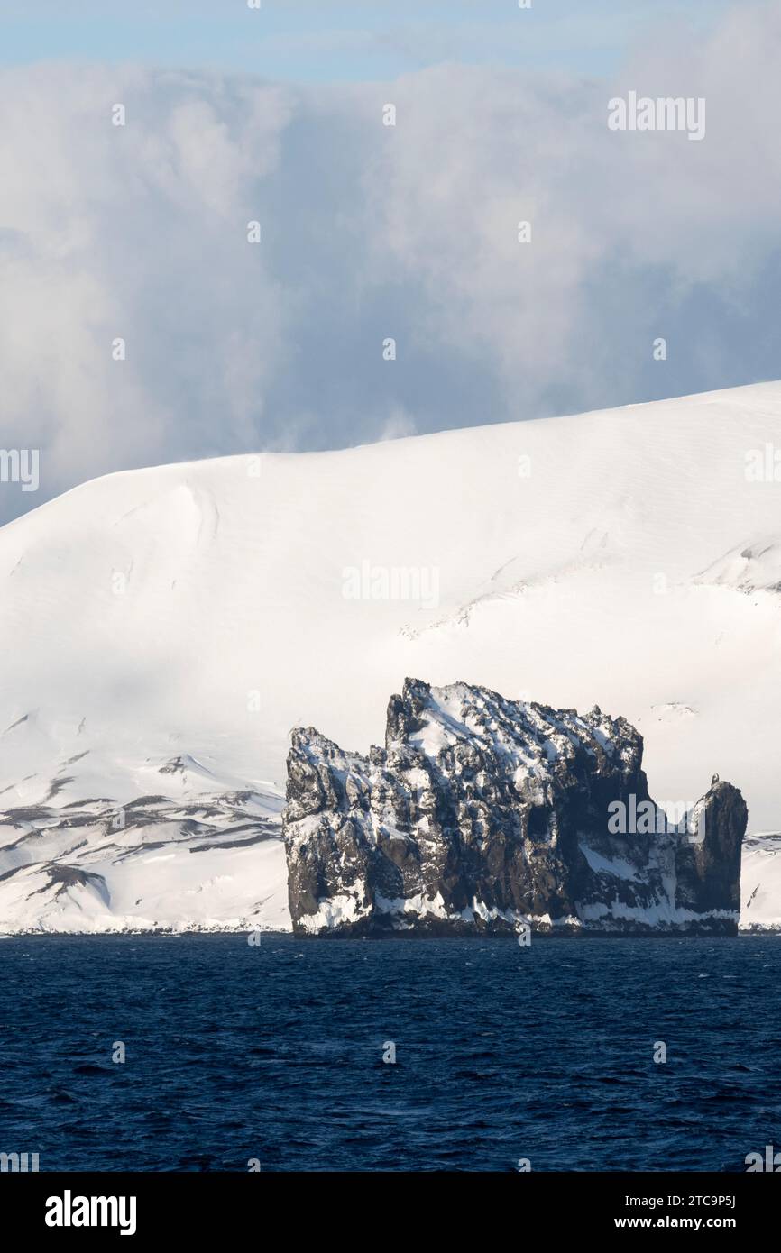 Antartide, Isole Shetland meridionali, stretto di Bransfield. New Rock con vista costiera dell'isola di Deception in lontananza Foto Stock