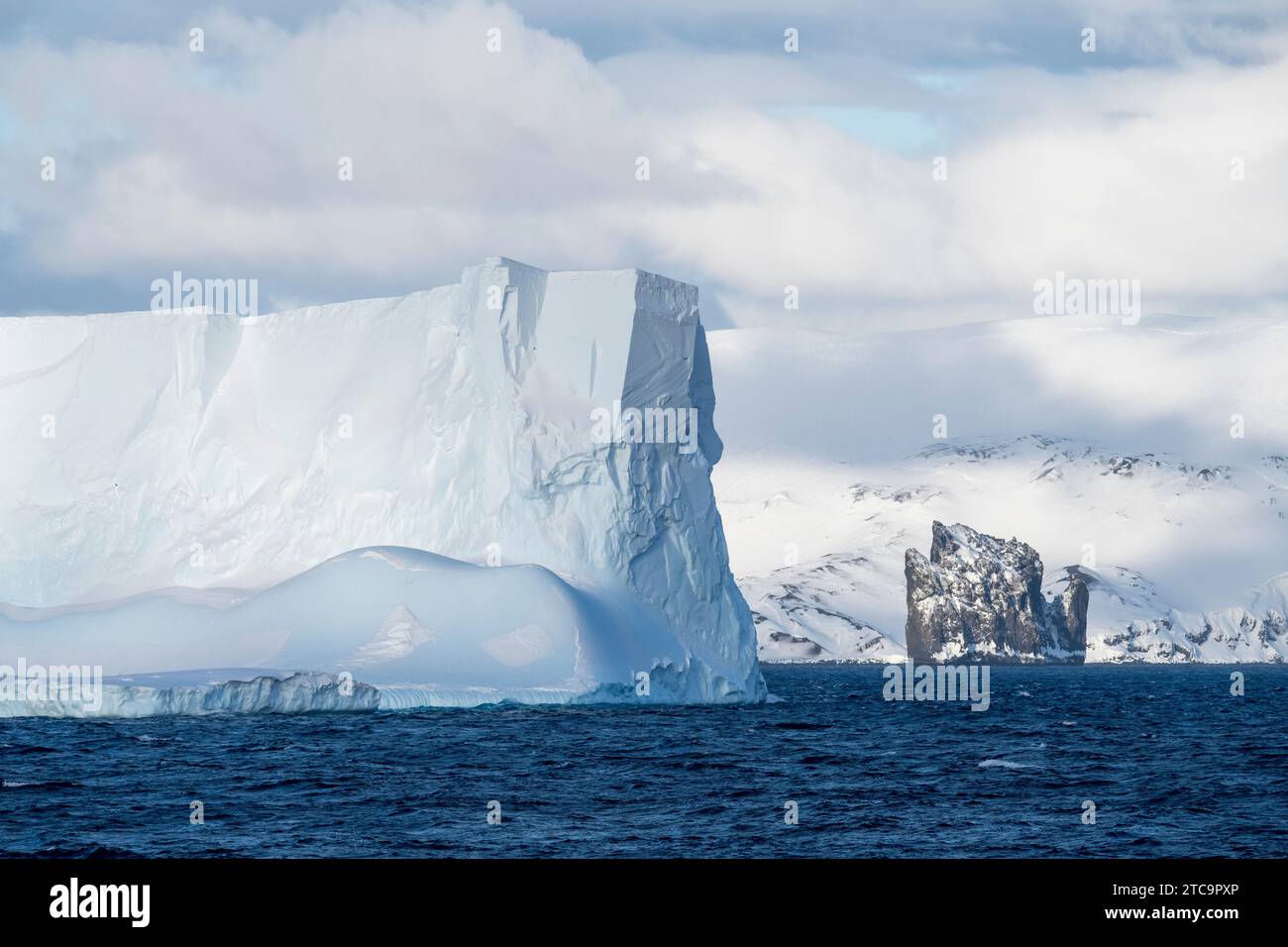 Antarcica, Isole Shetland meridionali, stretto di Bransfield. Grande iceberg e New Rock con vista costiera dell'isola Deception in lontananza. Foto Stock