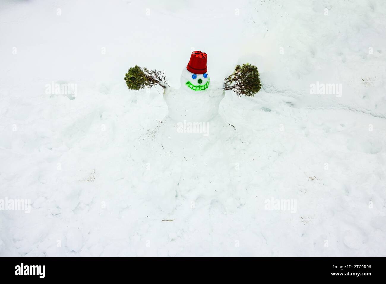 Vista ravvicinata di un simpatico pupazzo di neve, creato da un bambino in un giardino innevato. Foto Stock