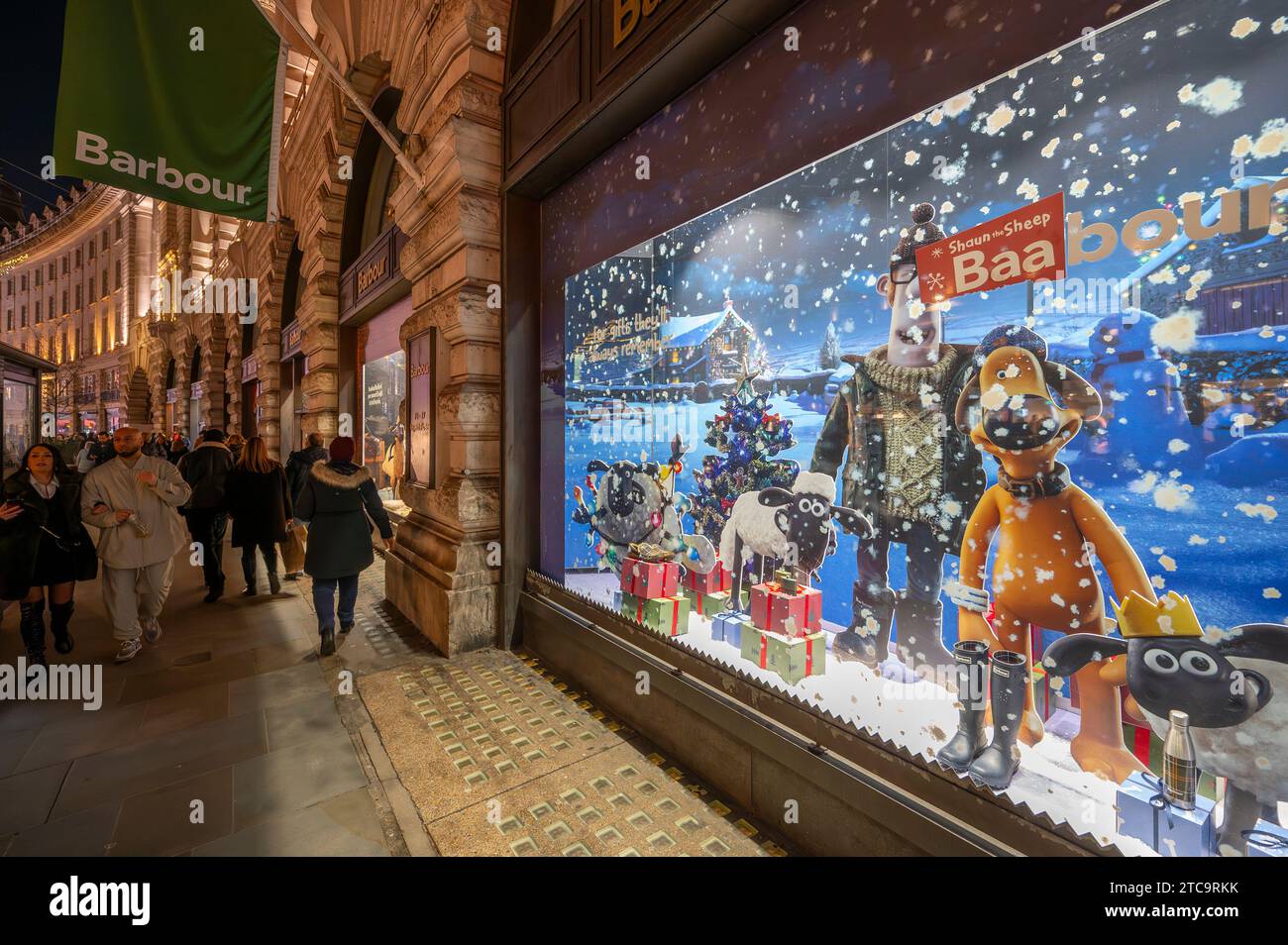 Londra, Regno Unito. 11 dicembre 2023.. Una serata vivace e secca nel centro di Londra con migliaia di visitatori che ammirano le impressionanti decorazioni natalizie e le vetrine dei negozi. Immagine: Negozio Barbour in Regent Street con finestre a tema Shaun the Sheep. Crediti: Malcolm Park/Alamy Live News Foto Stock