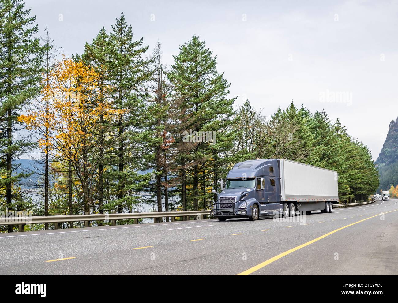 Carro classico grande carro di perforazione grigio semi-Truck con cabina estesa per il riposo del conducente del veicolo trasportando il carico in furgoni asciutti semirimorchi per la guida su strada Foto Stock