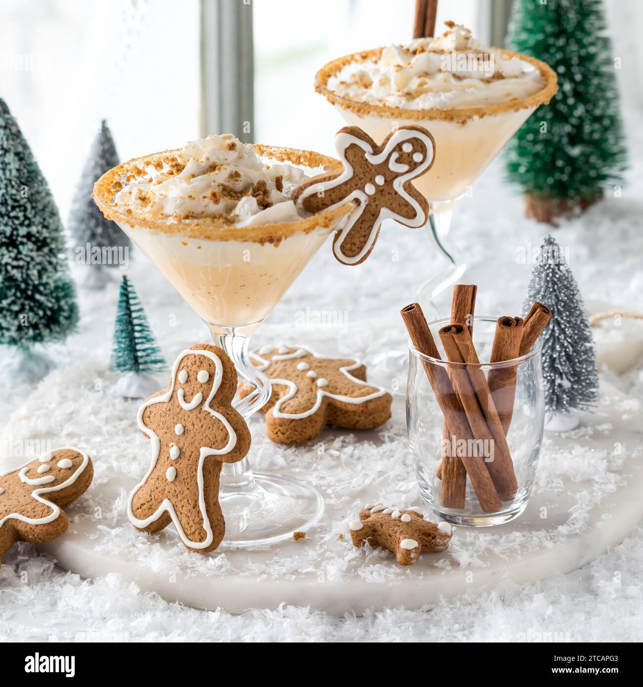 Martini di pan di zenzero conditi con panna montata e biscotti grattati spolverati. Foto Stock