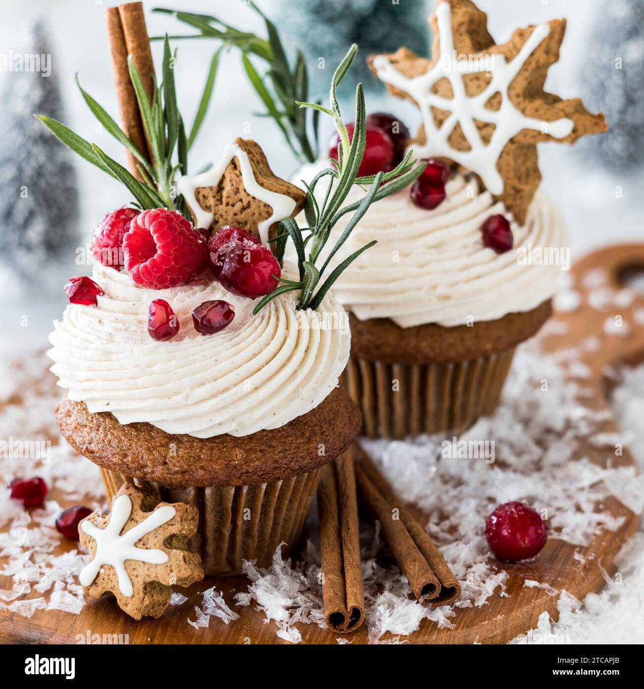Cupcake al pan di zenzero guarniti con frutti di bosco e biscotti con fiocchi di neve. Foto Stock