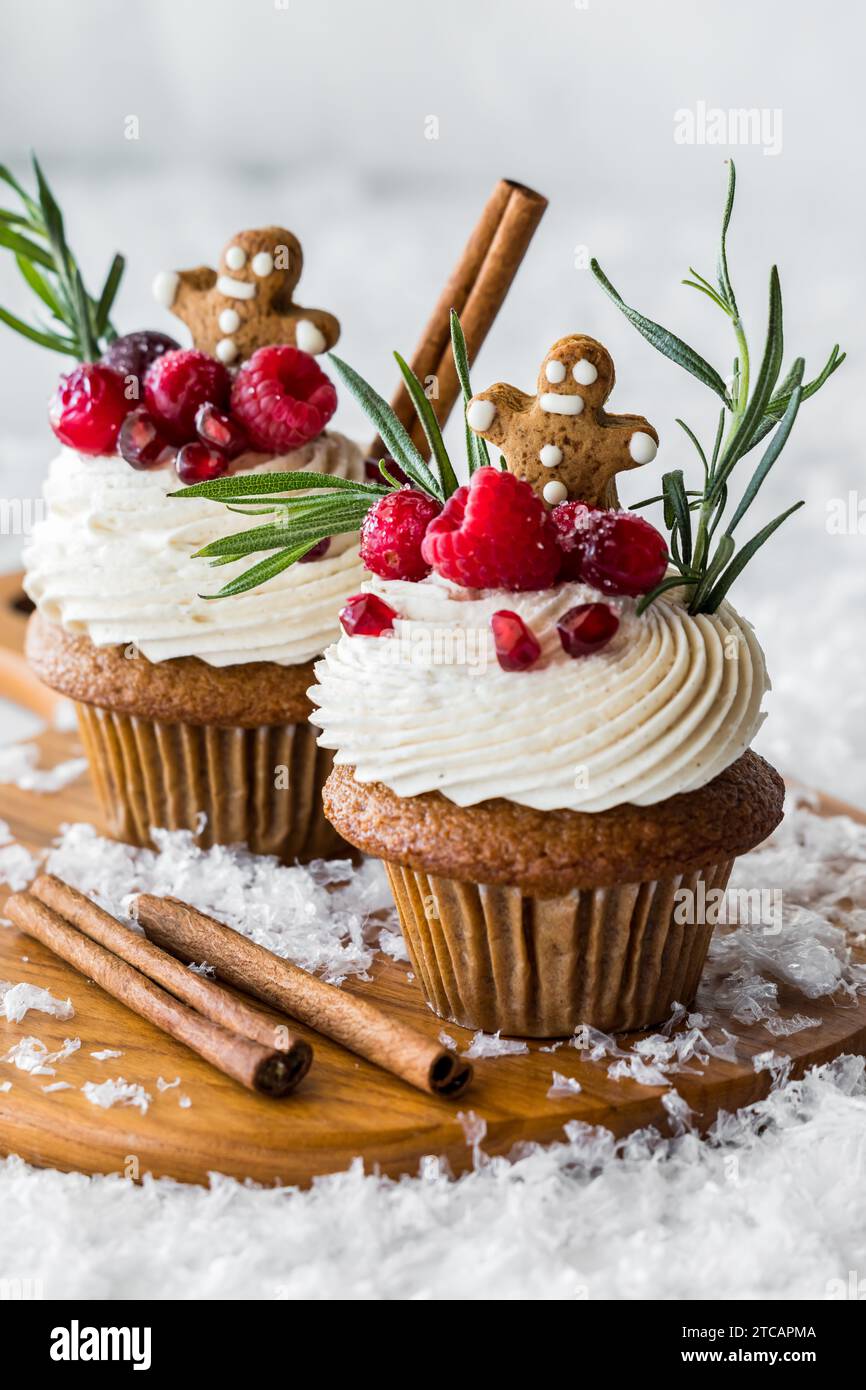 Cupcake di pan di zenzero con glassa alla crema, guarniti con frutti di bosco. Foto Stock
