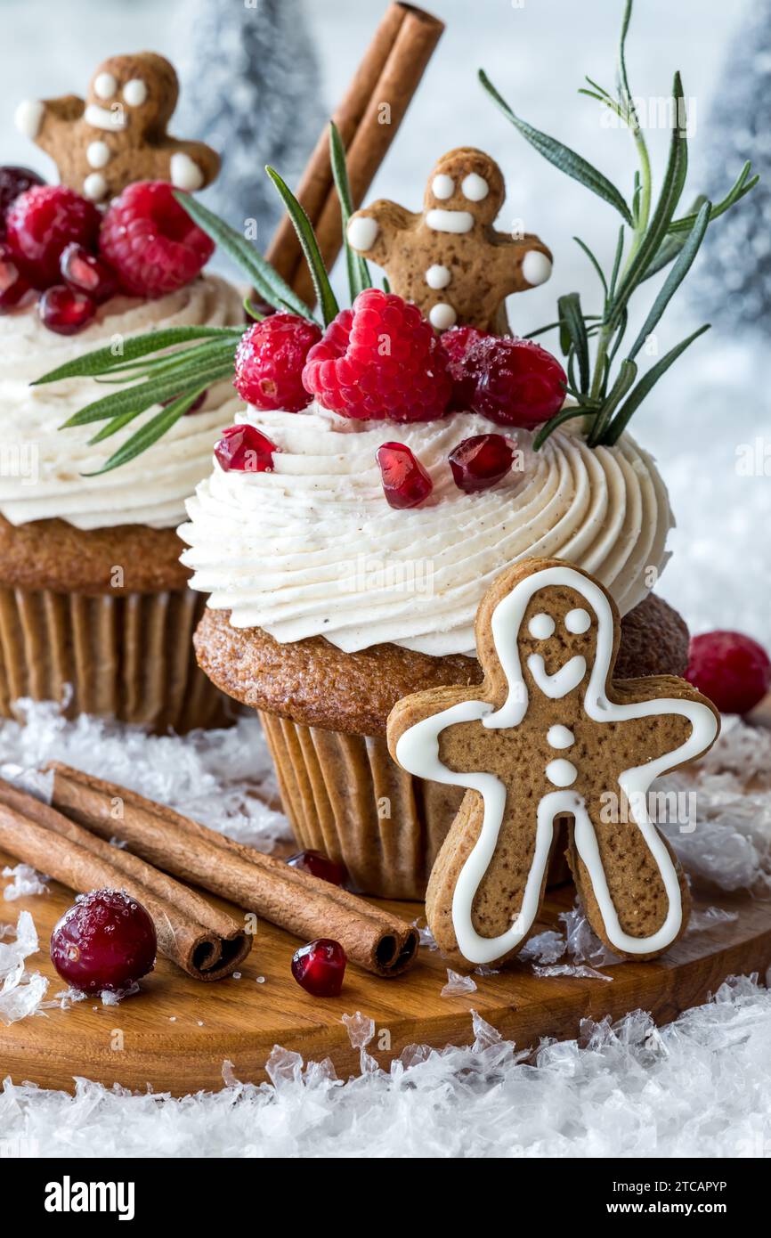Deliziosi cupcake al pan di zenzero con glassa alla crema, guarniti con frutti di bosco. Foto Stock