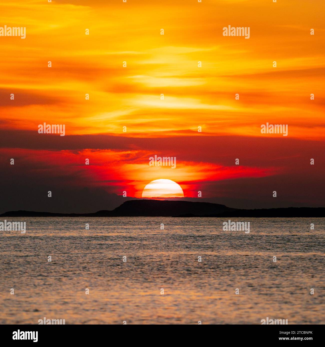 Una vista mozzafiato di un tranquillo tramonto sul mare, illuminato dal bagliore dorato di Lofoten, Norvegia Foto Stock