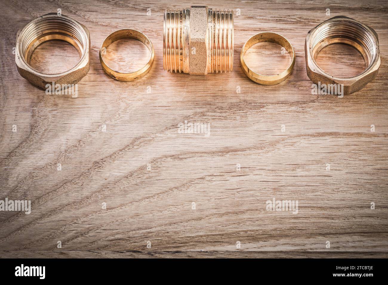 Raccordo filettato in ottone per tubo flessibile su scheda di legno concetto sanitario Foto Stock