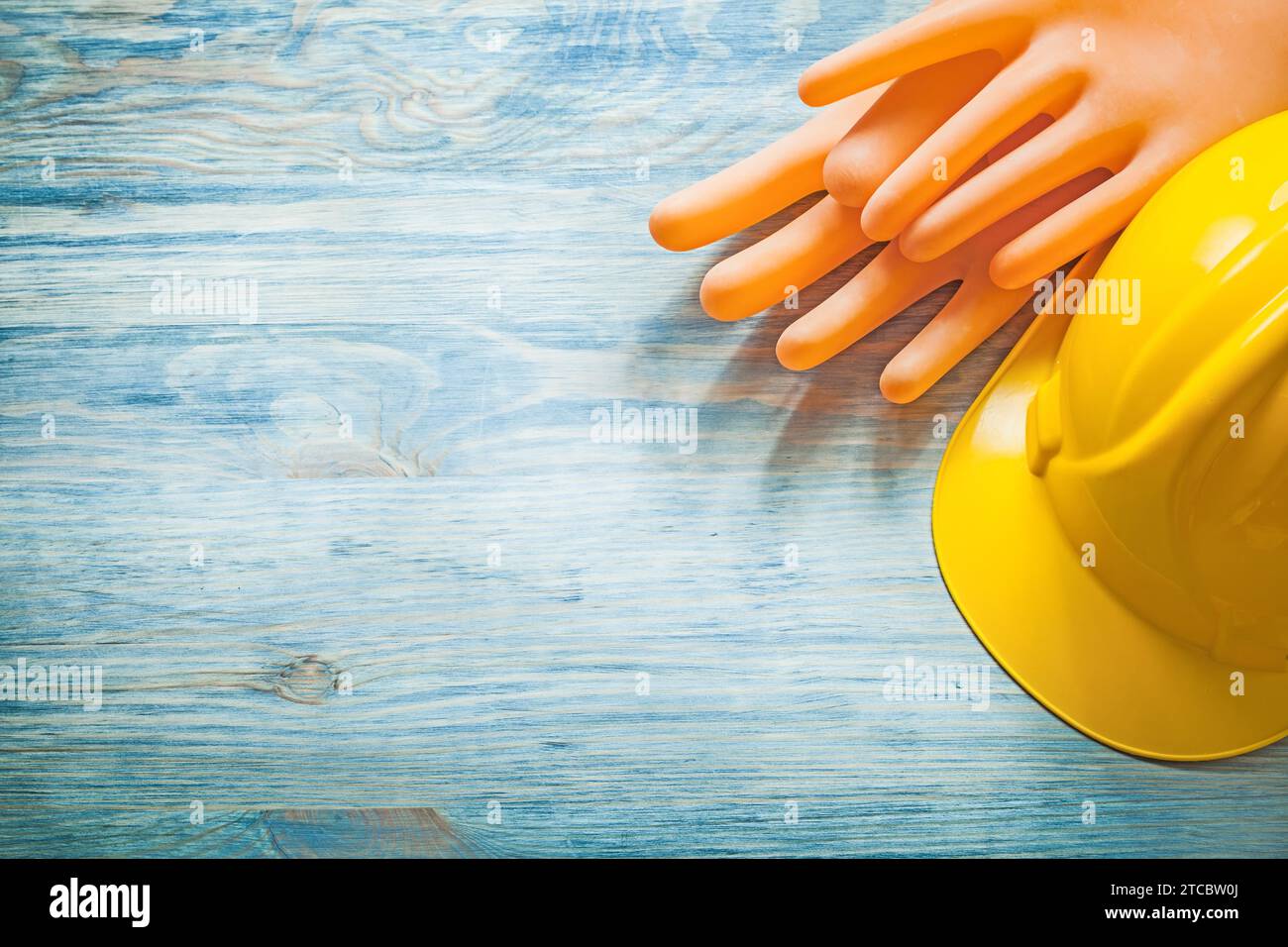 Composizione dei guanti dielettrici elmetto protettivo su tavola di legno concetto di elettricità Foto Stock