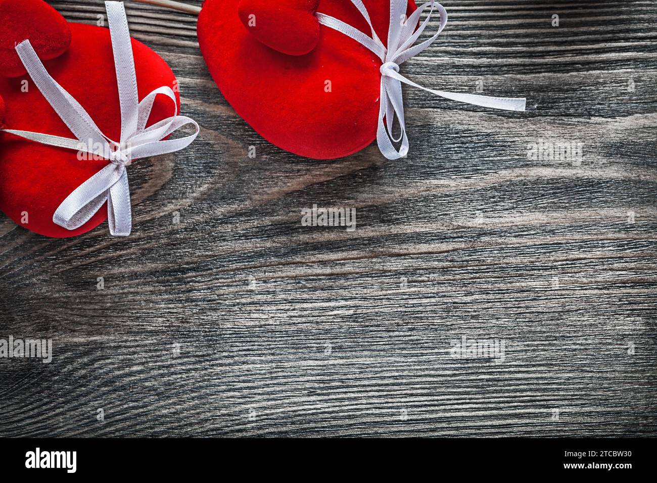 Composizione di cuori di tessuto rosso su tavola di legno Celebration Concept Foto Stock