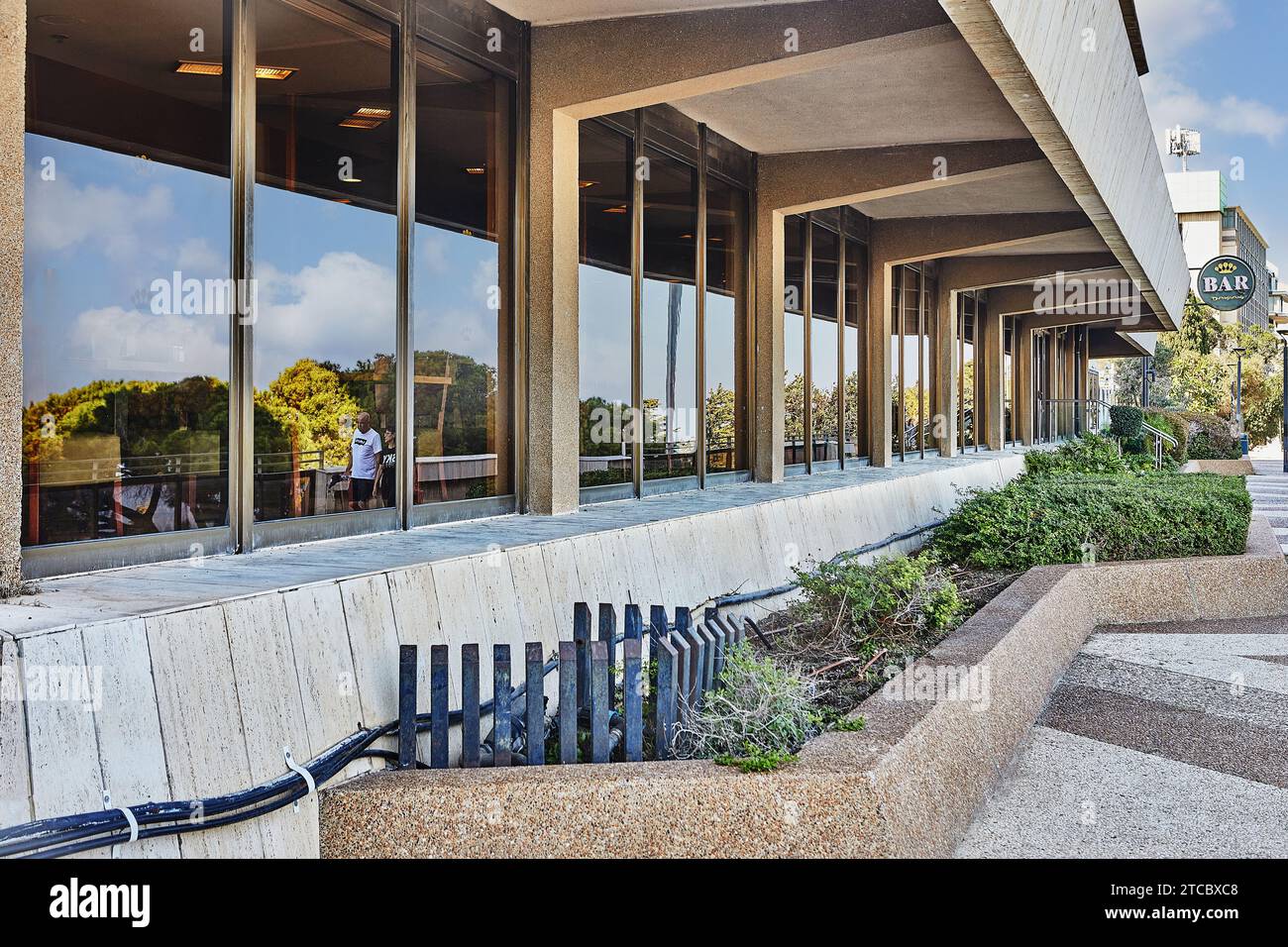 Haifa, Israele - 22 ottobre 2023: Una coppia amorevole passeggia accanto alle grandi finestre panoramiche di un lussuoso hotel mentre si gode la vista riflettente di Foto Stock