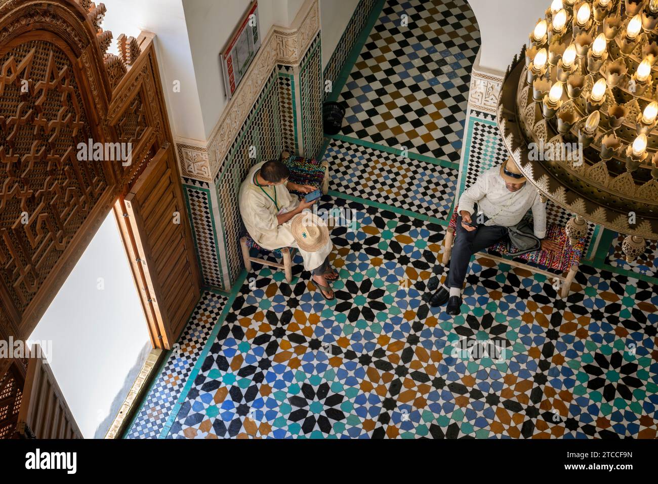 Marrakesh, Marocco: Due uomini che aspettano all'interno della Medersa Ben Youssef. Madrasa islamica (college) nella Medina di Marrakech. Foto Stock