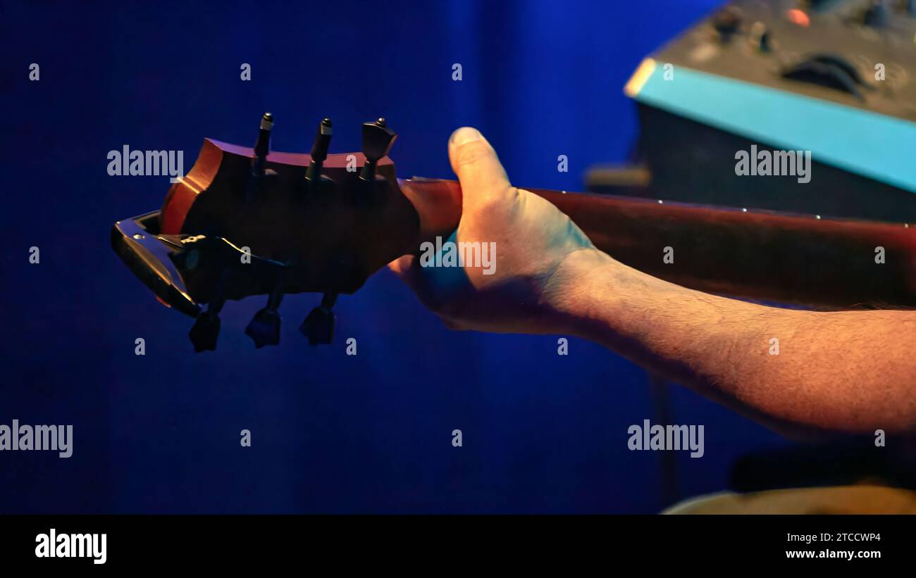 Immagine della mano di un chitarrista sul collo di una chitarra Foto Stock